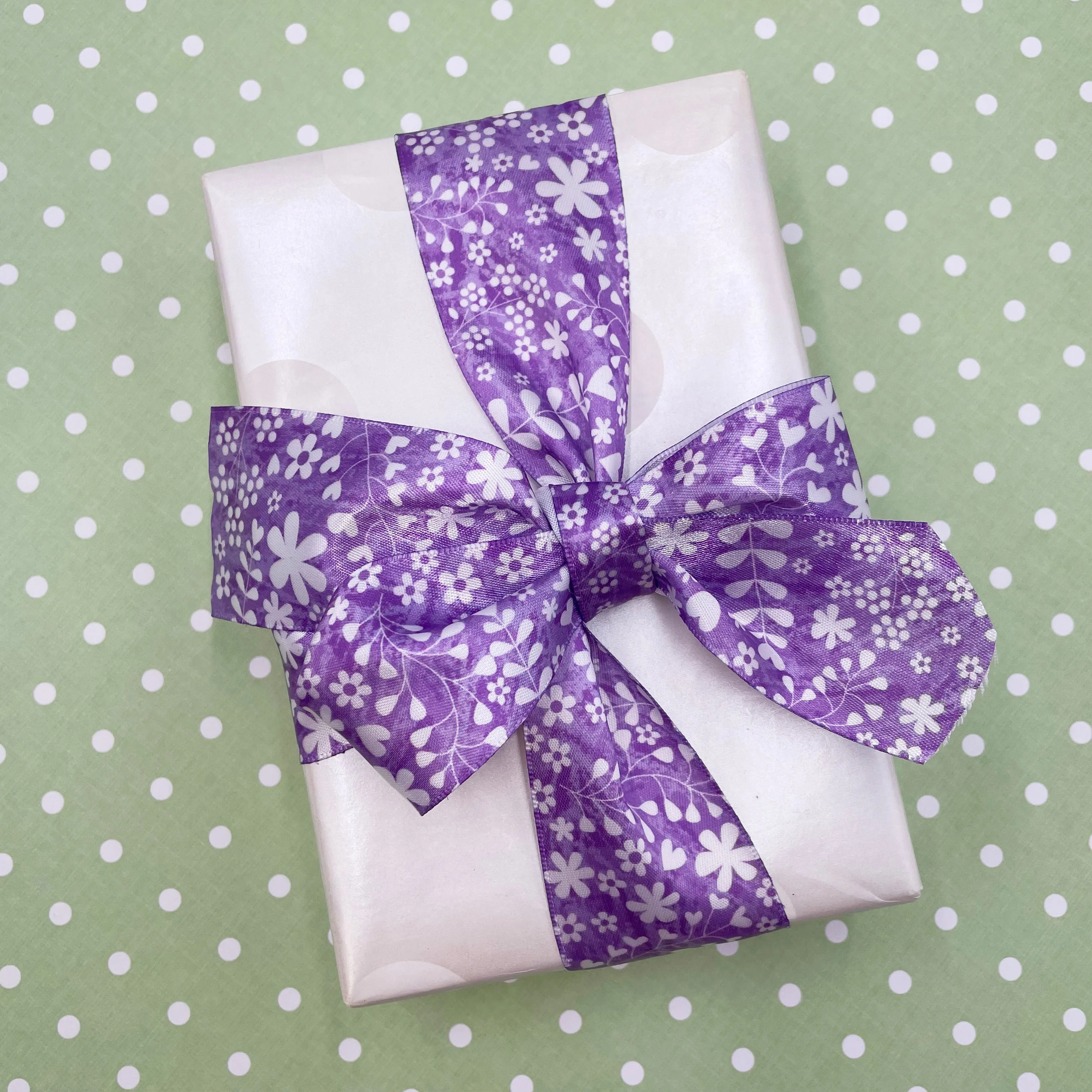 Spring floral print in white stencil on a lavender background printed on 1.5" white satin